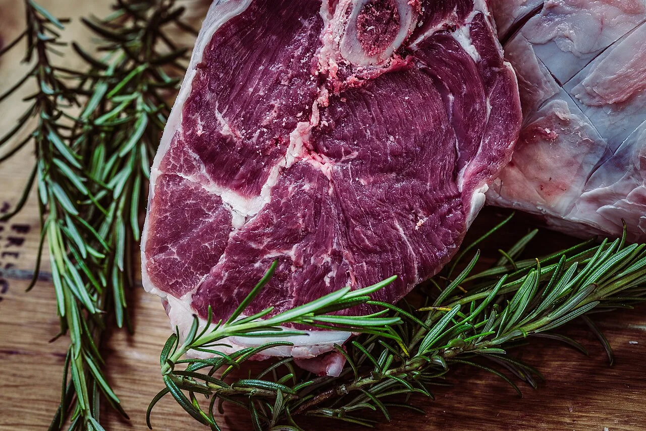 Côte de bœuf crue posée sur une planche avec du romarin (photo d'illustration)